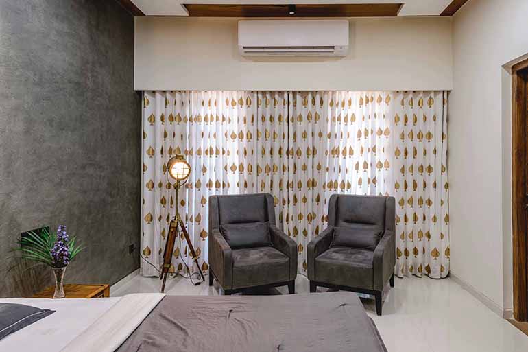 Bungalow design: the curtains were custom made using block prints of a spade in metallic shade.  The accent wall uses the Archi Concrete concept from Asian Paints. 