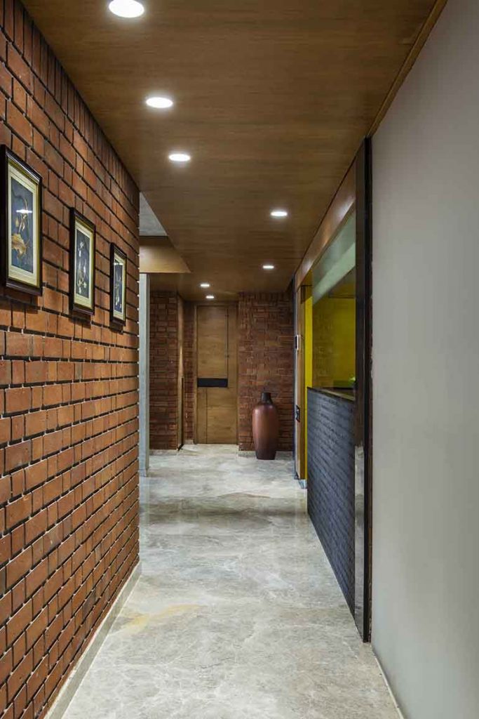 Foyer: natural stone flooring, exposed RCC ceiling and brick walls. 
Design: The Grid Architects
