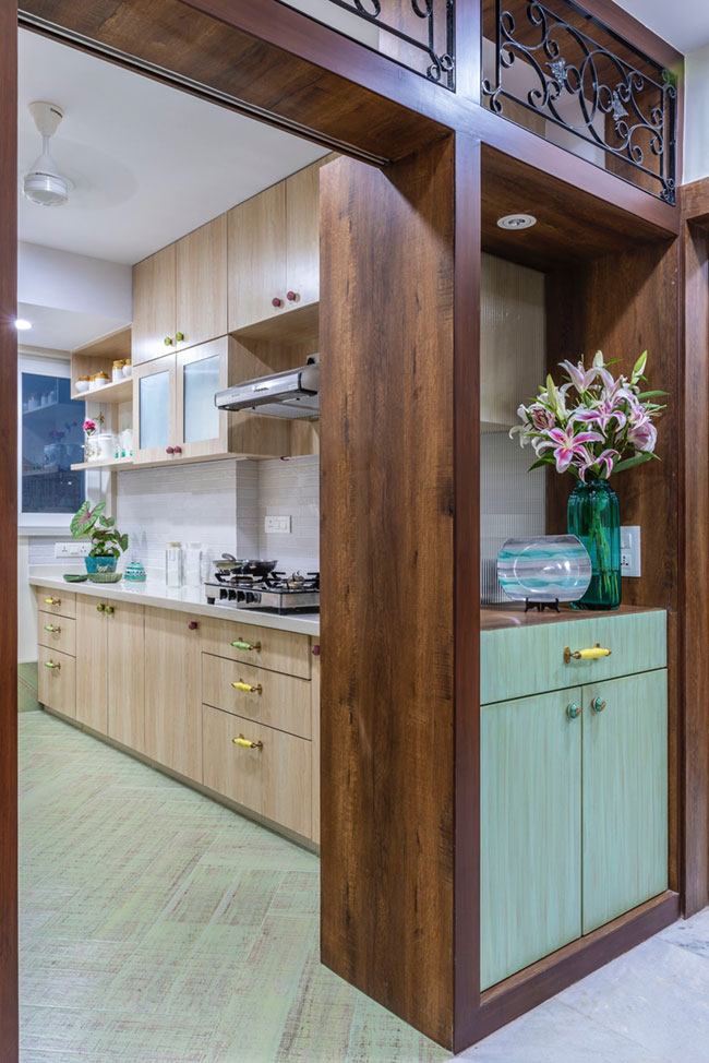 A sea green cabinet at the entrance of this open kitchen