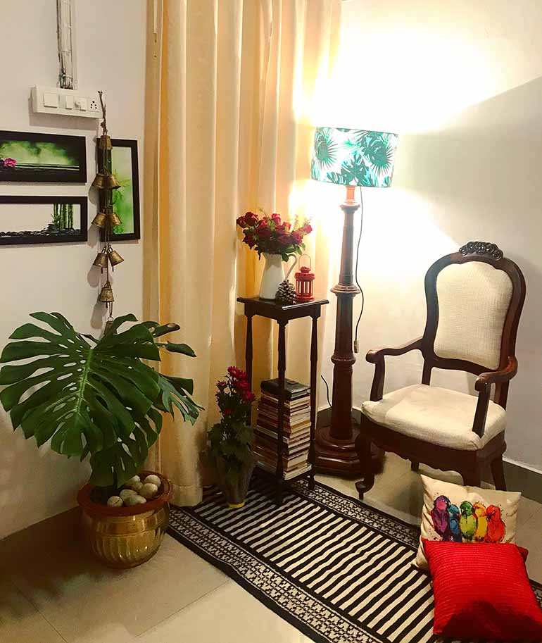 A corner of the living room. Sources- Lamp shade, wall frames from Amazon. Lamp, chair and the long stool are antiques. Flower vase from Ikea. DIY- A small DIY can be spotted here, kept on the floor. It's a cemented old hand towel that can be used as a flower vase,a planter or a candle stand. 