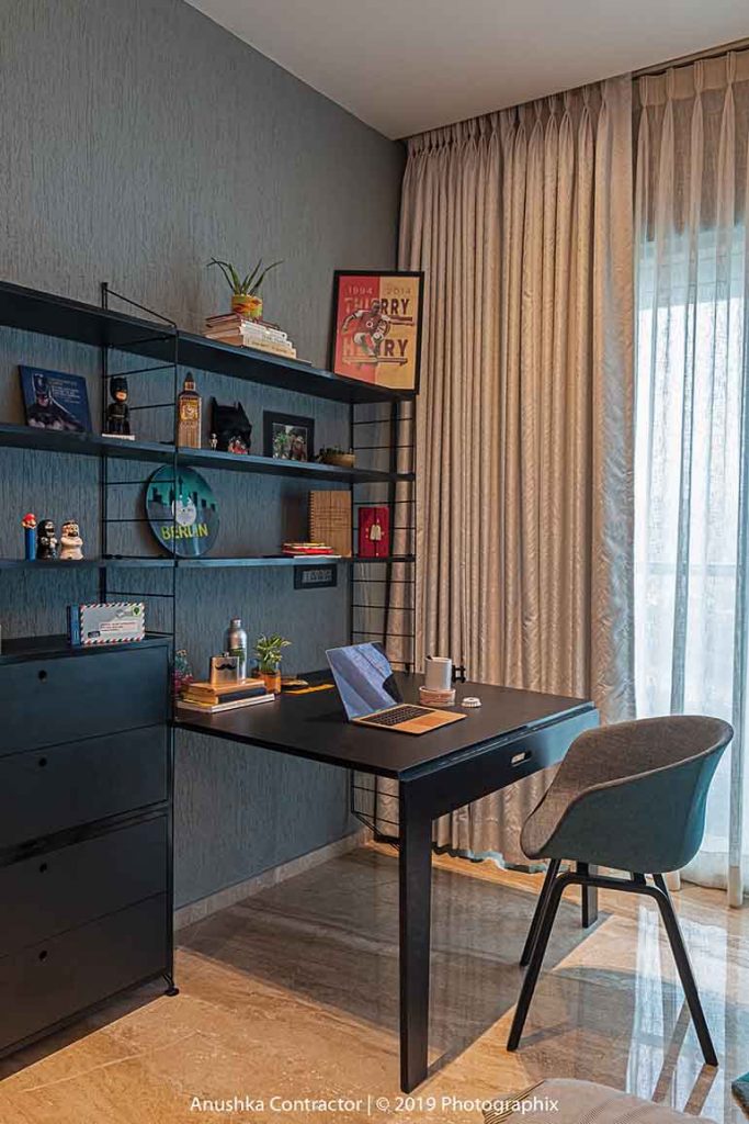 A compact home office set up with a floating desk fixed on one side and display / book shelf. Art for home - also found on this bookshelf. 