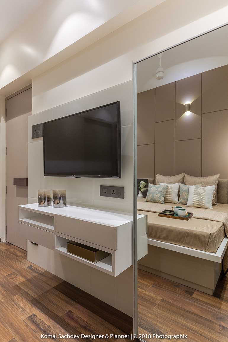 The bed faces a TV unit and a full length mirror.